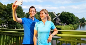 Ein Pärchen macht ein Selfie auf einer Fußgängerbrücke