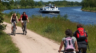 Radfahrer radeln am Kanal entlang © Emsland Bilddatenbank