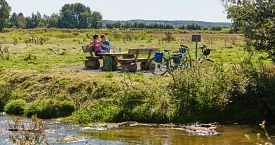 Radfahrer machen eine Pause an der Ohe im Naturpark Hümmling