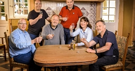 Eine Gruppe von Menschen sitzt bei Rosche in der alten Küche.