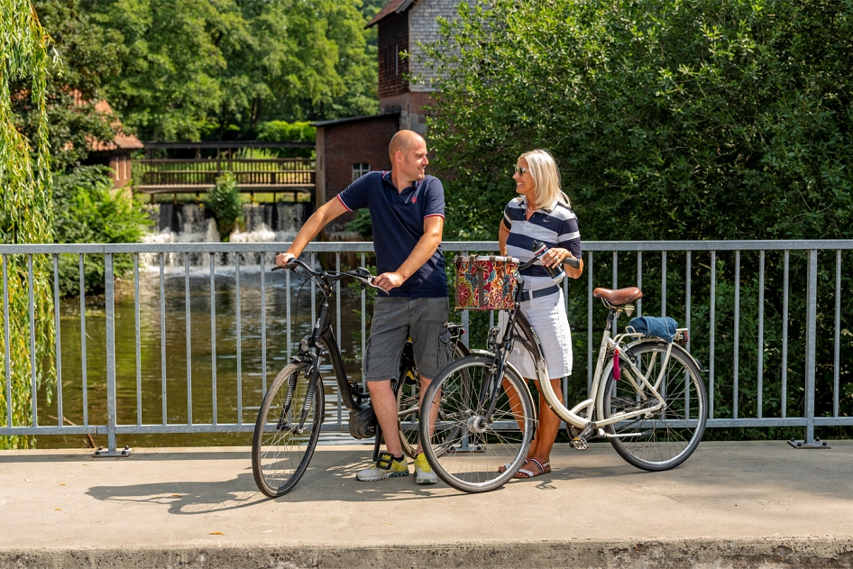 Zwei Radfahrer auf der Brücke vor der Meppener Herrenmühle.