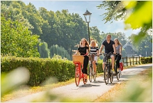 Eine Gruppe von vier Radfahrern radelt entlang des Dortmund-Ems-Kanal-Radweges an der Höltingmühle vorbei.