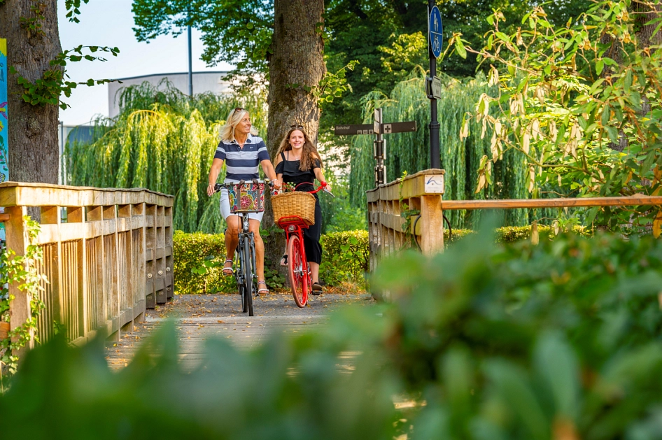 Zwei Radfahrerinnen überqueren die Holzbrücke zur Meppener Innenstadt. © Schöning Fotodesign